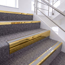 Mirrorflect Gold single insert chevron stair nosing, 65mm riser with Polar Grey insert, fitted on carpeted stairs