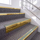 Mirrorflect Gold single insert chevron stair nosing, 65mm riser with Sage Green insert, fitted on carpeted stairs