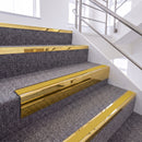 Mirrorflect Gold single insert chevron stair nosing, 65mm riser with Yellow insert, fitted on carpeted stairs