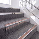 Mirrorflect Silver single insert chevron stair nosing, 65mm riser with Mid Brown insert, fitted on carpeted stairs