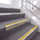 Mirrorflect Silver single insert chevron stair nosing, 65mm riser with Yellow insert, fitted on carpeted stairs