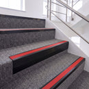 Satin Black single insert chevron stair nosing, 65mm riser with Red insert, fitted on carpeted stairs