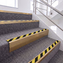Satin Bronze single insert chevron stair nosing, 65mm riser with Hazard black and yellow insert, fitted on carpeted stairs