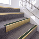 Satin Gold single insert chevron stair nosing, 65mm riser with Dark Green insert, fitted on carpeted stairs