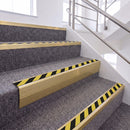 Satin Gold single insert chevron stair nosing, 65mm riser with Hazard black and yellow insert, fitted on carpeted stairs