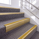 Satin Gold single insert chevron stair nosing, 65mm riser with Yellow insert, fitted on carpeted stairs