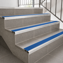 Slimline aluminium stair nosings with cobalt blue anti-slip inserts on grey tiled steps