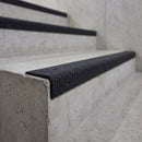 Black GRP stair nosing fitted to a bare concrete step on a plant room service stair