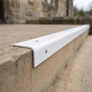 White GRP stair nosing fitted to an external stone step at a public building entrance