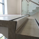 Raked back concealed fix aluminium stair nosing 65x55mm fitted to a concrete step in an office stairwell, black cover strip