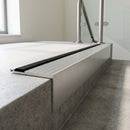 Concealed fix aluminium stair nosing 65x55mm with a square riser, fitted to a concrete step in an office stairwell, black cover strip