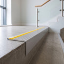 Concealed fix aluminium stair nosing 65x55mm with a square riser, fitted to a concrete step, yellow cover strip