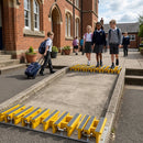 Yellow GRP stair nosings installed on school steps with students walking safely across anti-slip surfaces