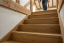 uPVC wood effect stair nosing in Rustic Oak — real-life installation on UK staircase with person using the stairs