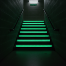 Glow-in-the-dark anti-slip tape on emergency exit stair nosings glowing vivid green in darkness