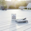 White anti-slip decking paint freshly applied to a garden timber deck with a paint roller and tin resting on the boards