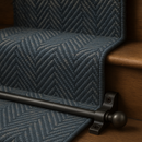 Dark pewter stair rods fitted on slate blue herringbone runner — elegant traditional interior