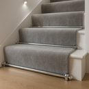 Chrome stair rods on silver-grey plush runner carpet — minimalist UK home staircase
