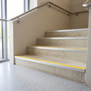 DDA aluminium stair nosings with yellow anti-slip inserts fitted to concrete entrance steps in a school building, stainless handrail alongside