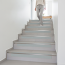 Heavy duty tile-in stair nosing in Ice Grey — real-life installation with person using tiled UK staircase