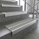 Dolphin grey twin anti-slip PVC inserts in square edge aluminium stair nosings on concrete steps in a glazed stairwell
