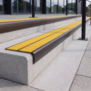 Dark bronze 84mm double channel bullnose aluminium stair nosing with twin Brimstone yellow gritted exterior-grip inserts fitted on leisure centre entrance steps