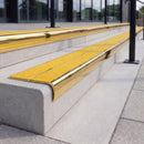 Mirror polished gold 84mm double channel bullnose aluminium stair nosing with twin Brimstone yellow gritted exterior-grip inserts fitted on leisure centre entrance steps
