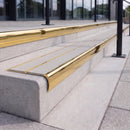 Mirror polished gold 84mm double channel bullnose aluminium stair nosing with twin Everest light grey gritted exterior-grip inserts fitted on leisure centre entrance steps