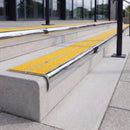 Mirror polished silver 84mm double channel bullnose aluminium stair nosing with twin Brimstone yellow gritted exterior-grip inserts fitted on leisure centre entrance steps
