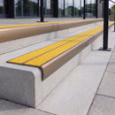Satin bronze 84mm double channel bullnose aluminium stair nosing with twin Brimstone yellow gritted exterior-grip inserts fitted on leisure centre entrance steps