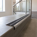 Bullnose double channel aluminium stair nosing 98x40mm fitted to a concrete step, twin Granite Castellated inserts
