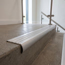 Bullnose double channel aluminium stair nosing 98x40mm fitted to a concrete step, twin Satin Aluminium inserts