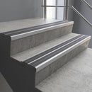 Aluminium stair nosing 90x32mm double channel fitted to a concrete step - Mill Aluminium finish with twin Flint Castellated inserts