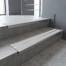 Aluminium stair nosing 90x32mm double channel fitted to a concrete step - Mill Aluminium finish with twin Polar Grey Smooth Textured inserts
