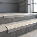 Aluminium stair nosing 90x32mm double channel fitted to a concrete step - Mill Aluminium finish with twin Porth Stone Castellated inserts