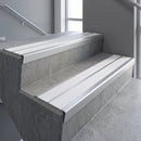 Aluminium stair nosing 90x32mm double channel fitted to a concrete step - Mill Aluminium finish with twin White Castellated inserts