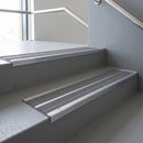 Aluminium stair nosing 90x32mm double channel fitted to a concrete step - Polished Aluminium finish with twin Flint Castellated inserts