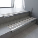 Aluminium stair nosing 90x32mm double channel fitted to a concrete step - Polished Aluminium finish with twin Light Grey Castellated inserts