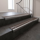 Aluminium stair nosing 90x32mm double channel fitted to a concrete step - Polished Aluminium finish with twin Peat Castellated inserts
