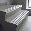 Aluminium stair nosing 90x32mm double channel fitted to a concrete step - Polished Aluminium finish with twin Polished Aluminium inserts