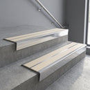 Aluminium stair nosing 90x32mm double channel fitted to a concrete step - Polished Aluminium finish with twin Porth Stone Castellated inserts