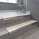 Aluminium stair nosing 90x32mm double channel fitted to a concrete step - Polished Aluminium finish with twin Porth Stone Smooth Textured inserts
