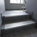 Aluminium stair nosing 90x32mm double channel fitted to a concrete step - Polished Aluminium finish with twin Satin Aluminium inserts