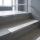 Aluminium stair nosing 90x32mm double channel fitted to a concrete step - Polished Aluminium finish with twin White Castellated inserts
