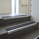 Aluminium stair nosing 90x32mm double channel fitted to a concrete step - Satin Aluminium finish with twin Black Castellated inserts