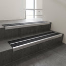 Aluminium stair nosing 90x32mm double channel fitted to a concrete step - Satin Aluminium finish with twin Black Olympic Grip inserts