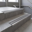 Aluminium stair nosing 90x32mm double channel fitted to a concrete step - Satin Aluminium finish with twin Flint Castellated inserts