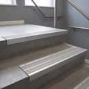 Aluminium stair nosing 90x32mm double channel fitted to a concrete step - Satin Aluminium finish with twin Light Grey Castellated inserts
