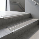 Aluminium stair nosing 90x32mm double channel fitted to a concrete step - Satin Aluminium finish with twin Light Grey Smooth Textured inserts