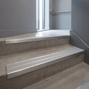 Aluminium stair nosing 90x32mm double channel fitted to a concrete step - Satin Aluminium finish with twin Polar Grey Castellated inserts